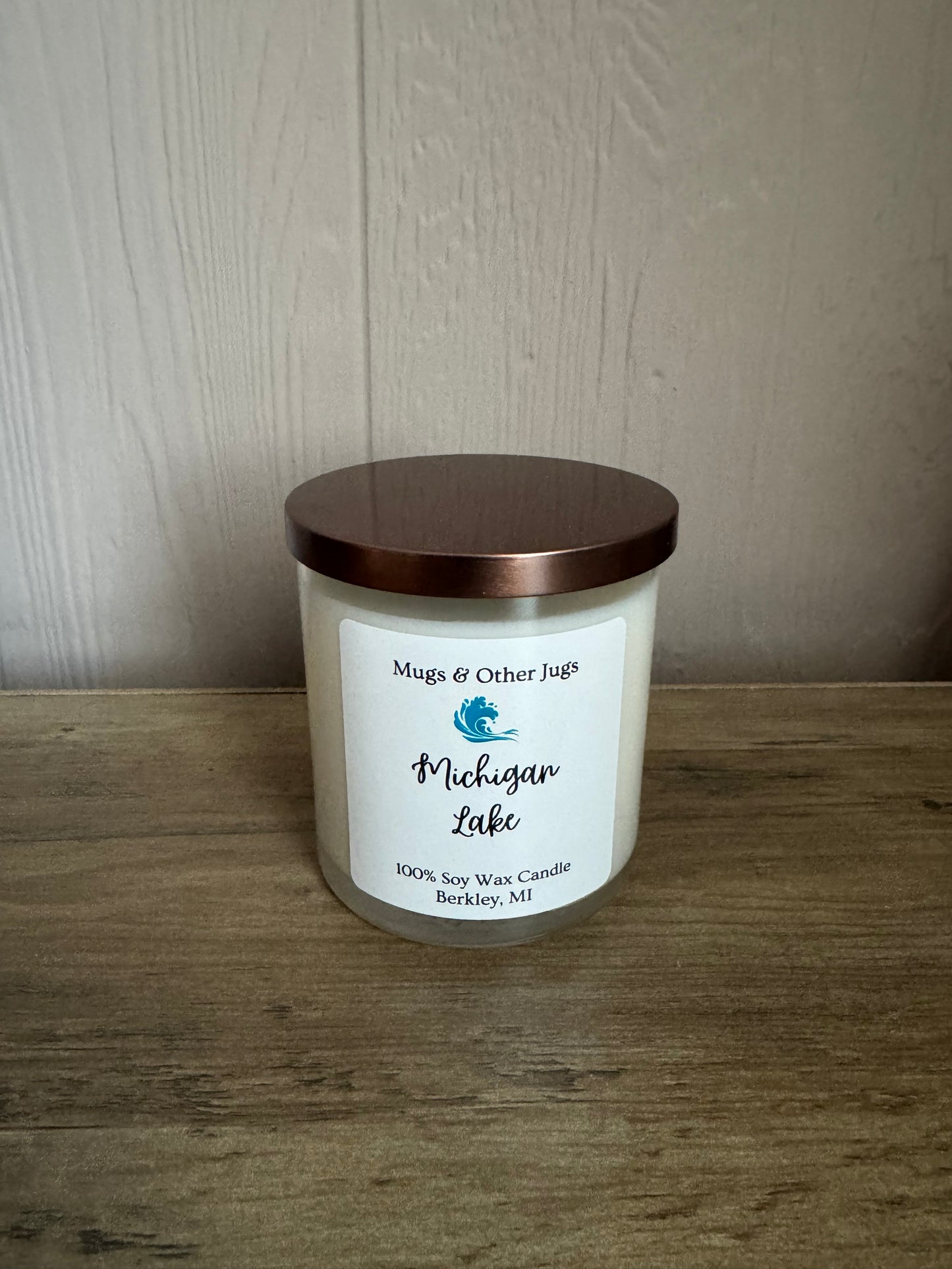 Candle with a label on a wooden surface