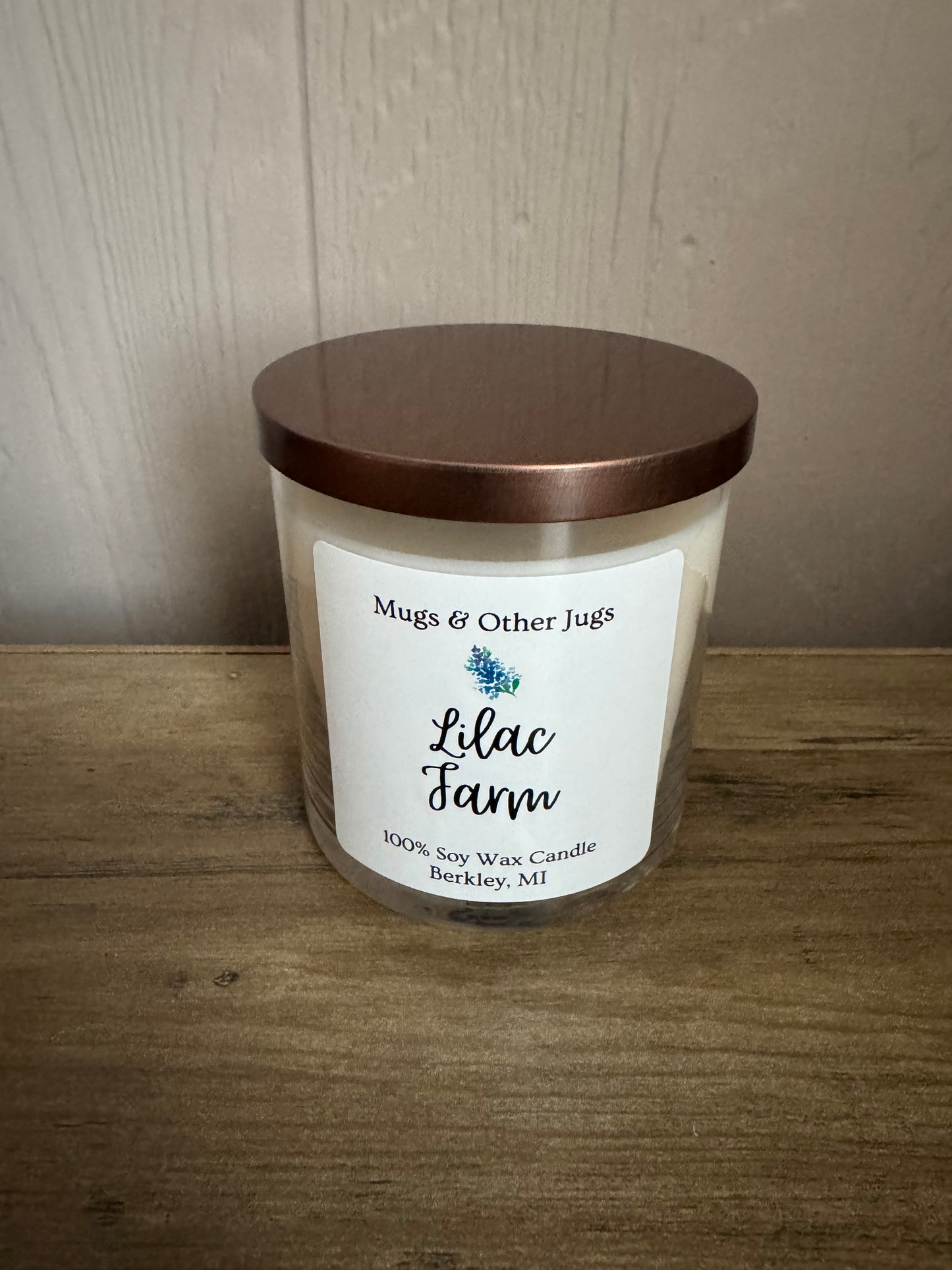 Candle with a label on a wooden surface