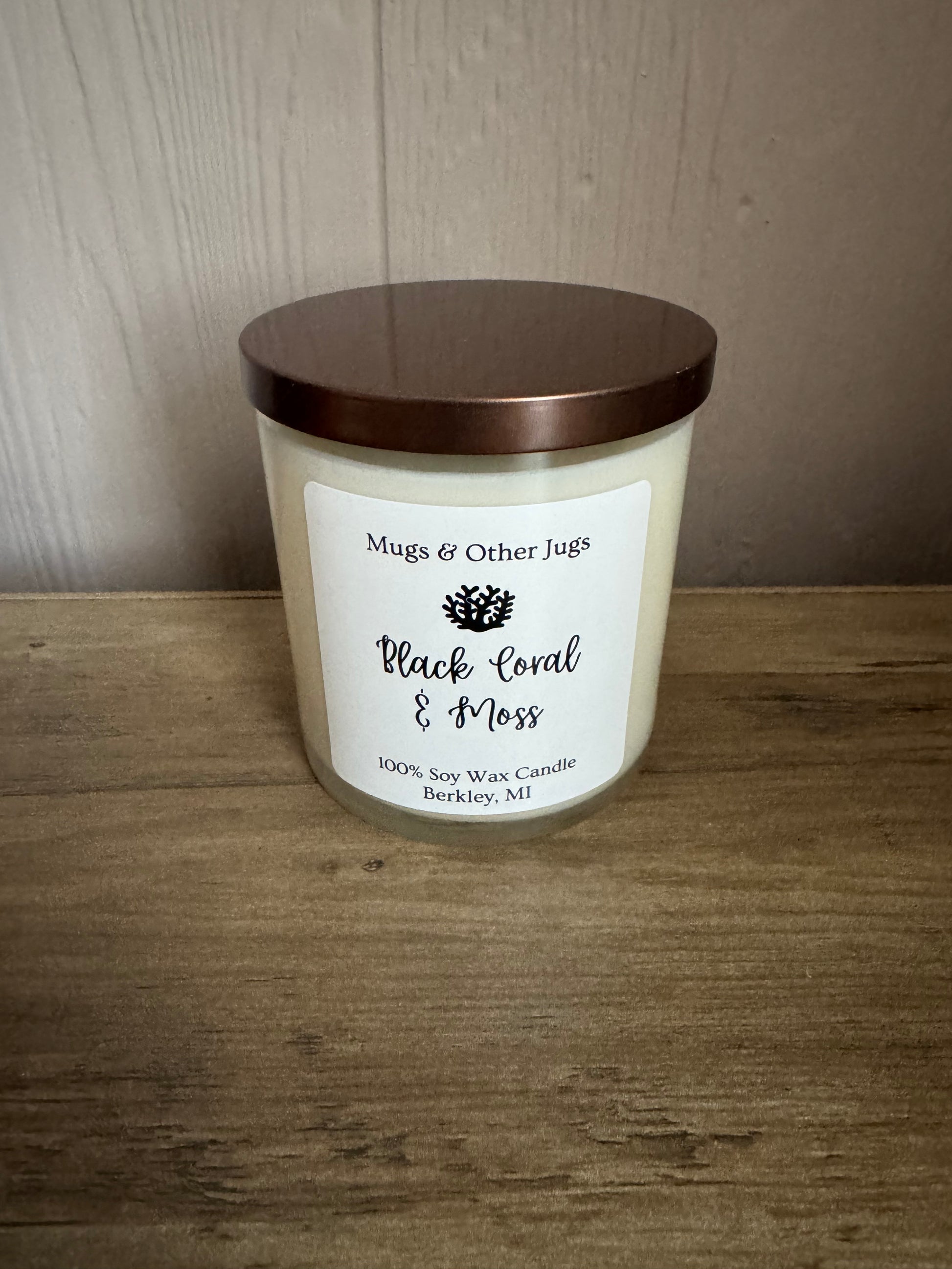Candle with a label on a wooden surface