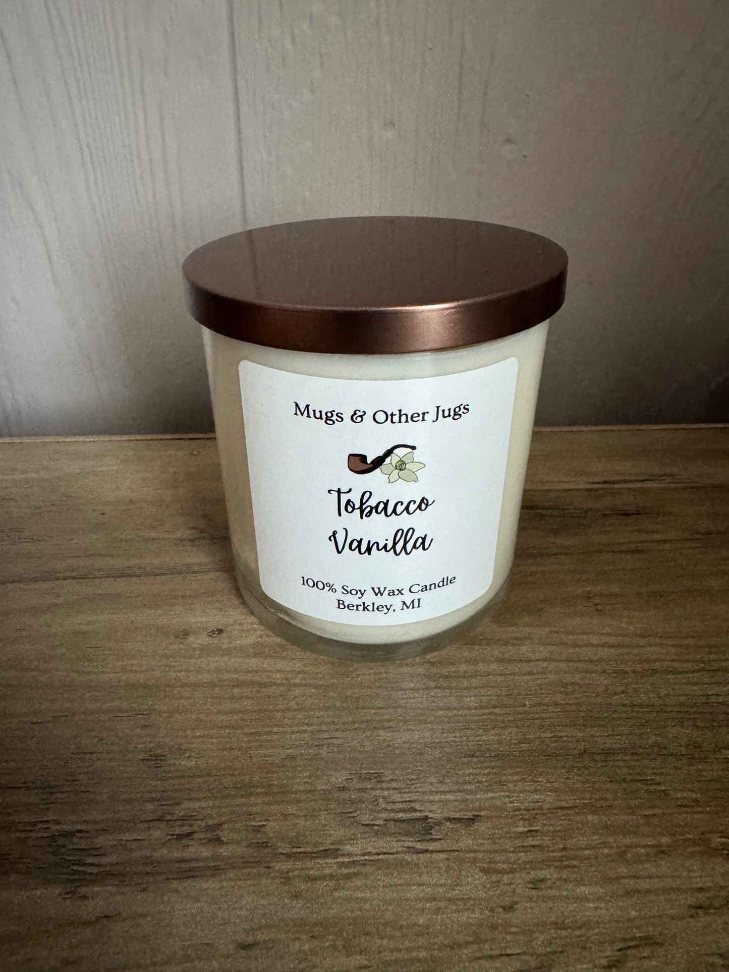 Candle with a label on a wooden surface