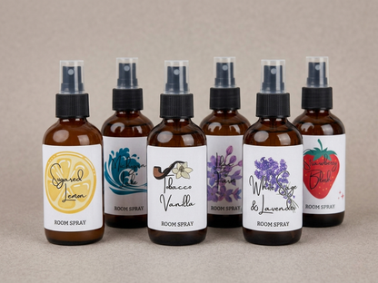 Set of six room spray bottles with various scents on a neutral background