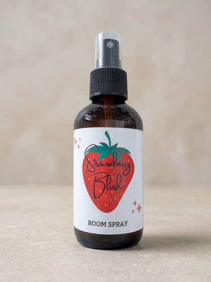 Room spray bottle labeled 'Strawberry Blush' on a beige background